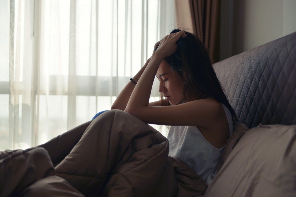 woman sitting in a bed feeling so down