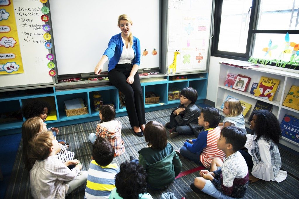 preschool teacher picking a student to recite in her class